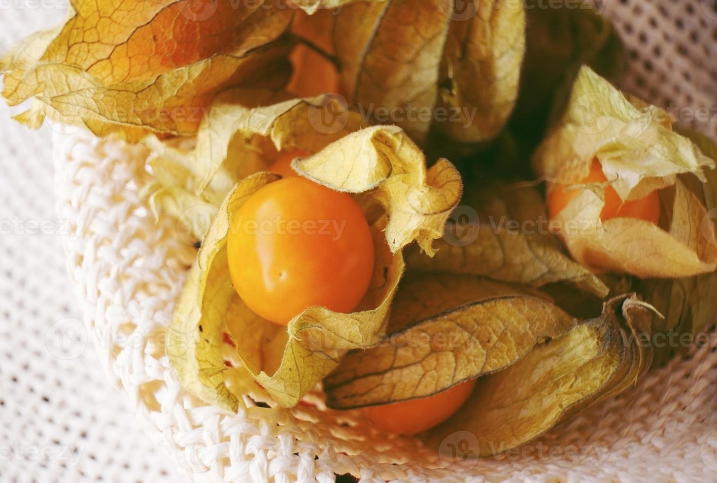 beau gros plan macro d'un fruit savoureux orange nommé physalis du pérou, amérique du sud, dans un joli panier textile photo