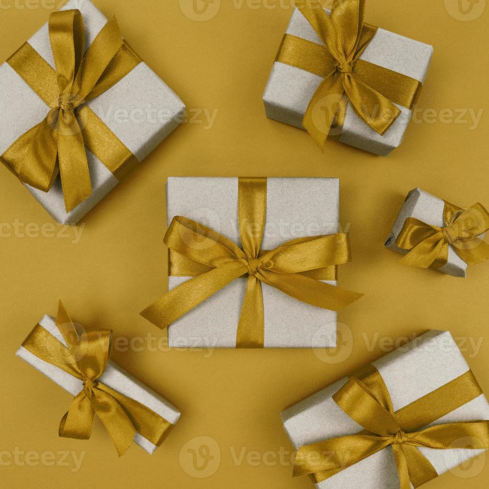 coffrets cadeaux emballés dans du papier kraft avec des rubans jaunes et des arcs. mise à plat monochrome festive. photo