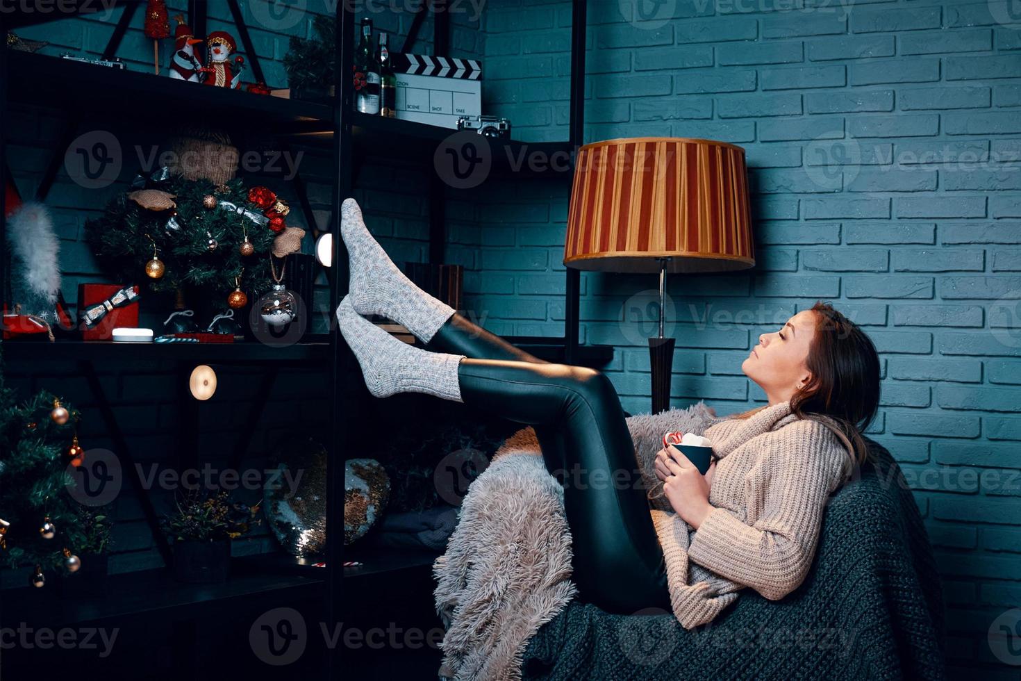 femme avec une tasse de cacao assise sur une chaise. photo