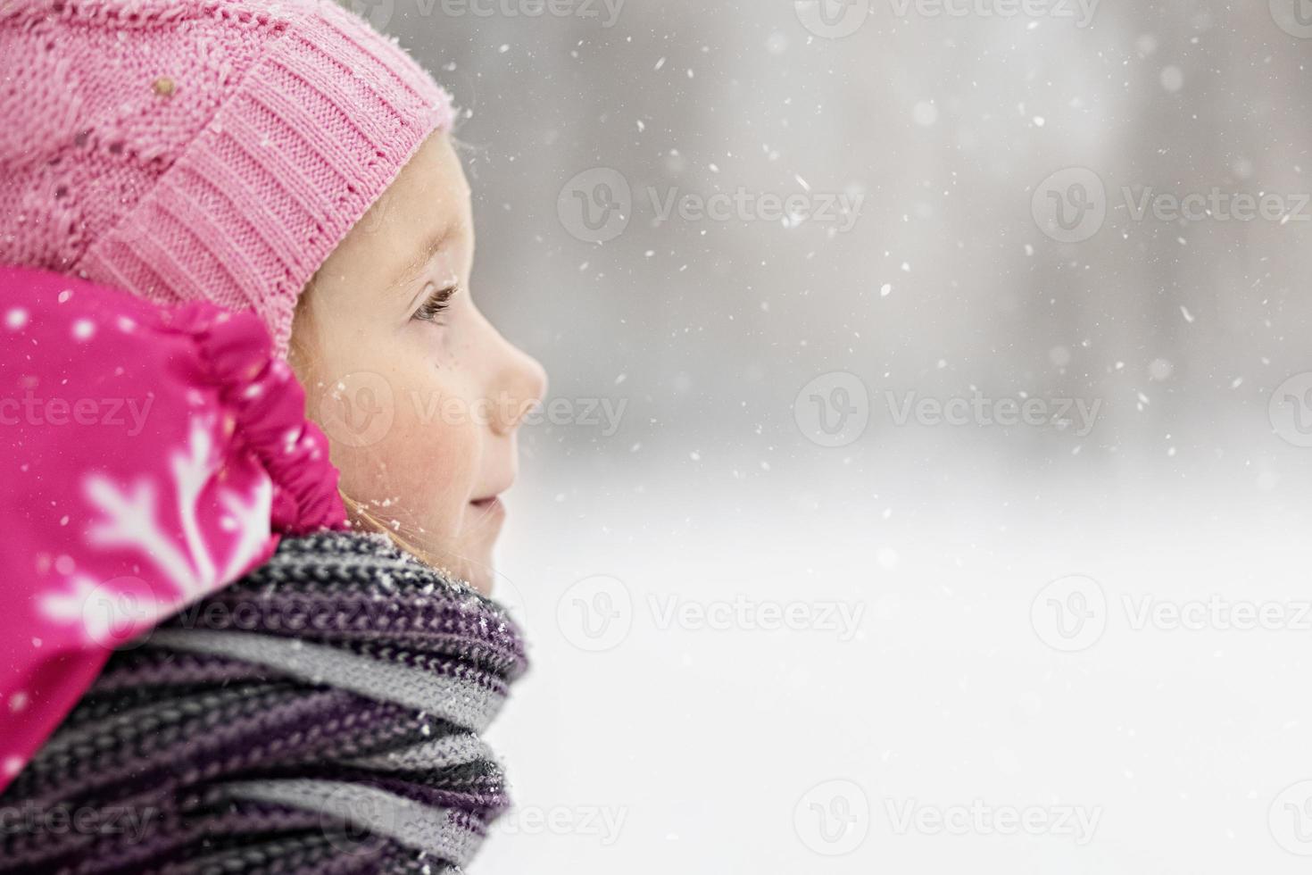 portrait d'une petite fille en gros plan rose. un enfant profite de la neige. vacances de Noël photo