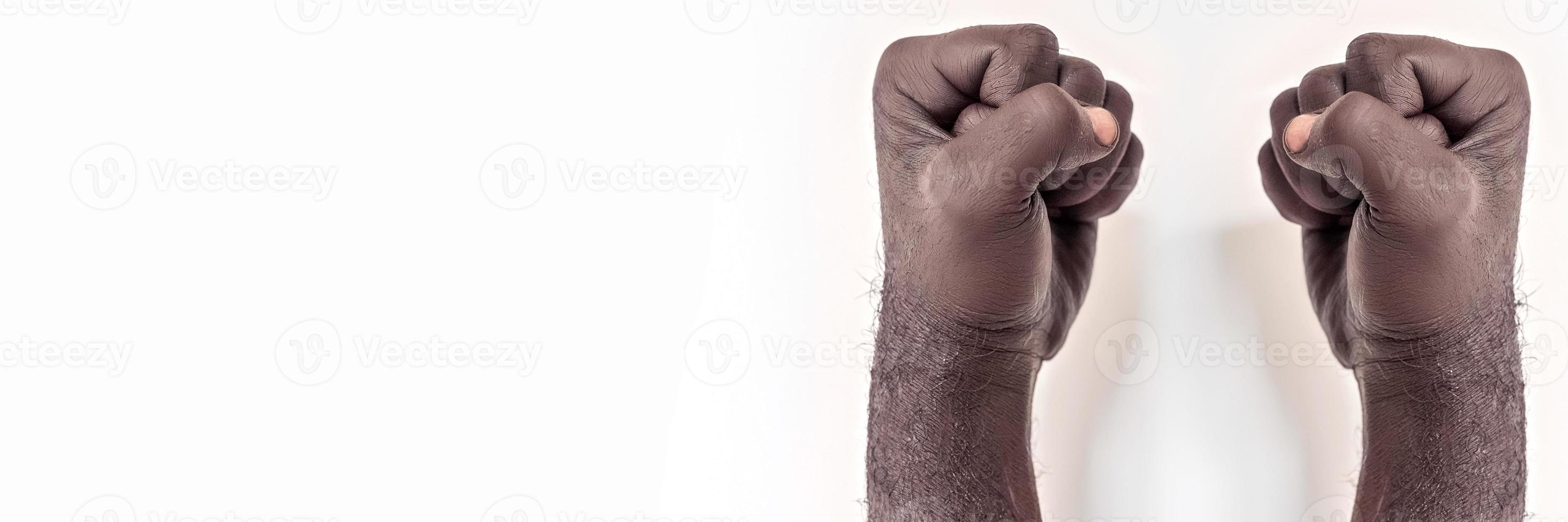 mains masculines serrées dans un poing sur un fond blanc. un symbole de la lutte pour les droits des noirs en Amérique. protester contre le racisme.banner. photo