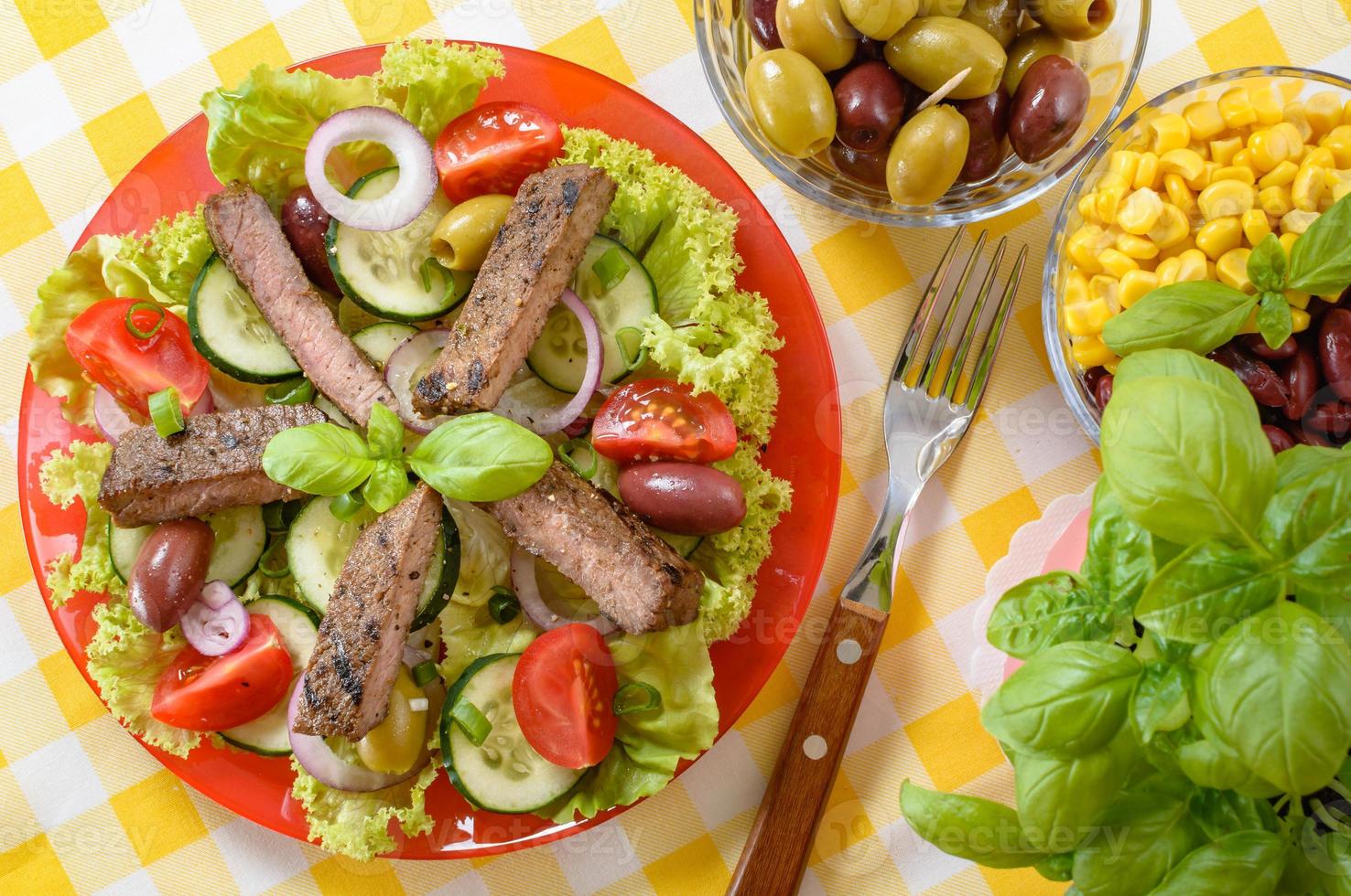 salade de boeuf dans l'assiette. viande de boeuf grillée avec une savoureuse sélection de légumes. photo