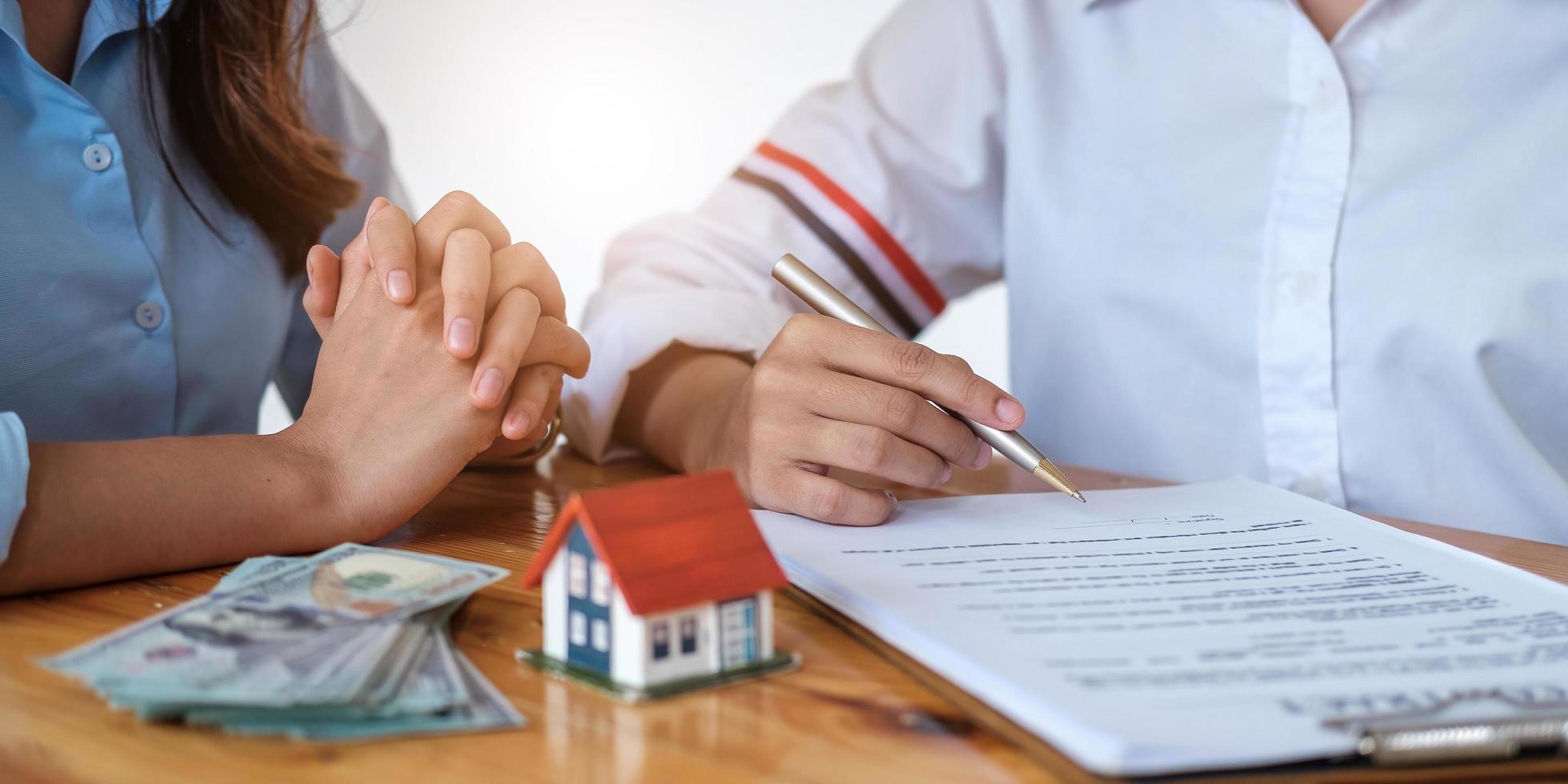 agent immobilier expérimenté montrant le modèle de maison au client et prêt à signer un contrat photo