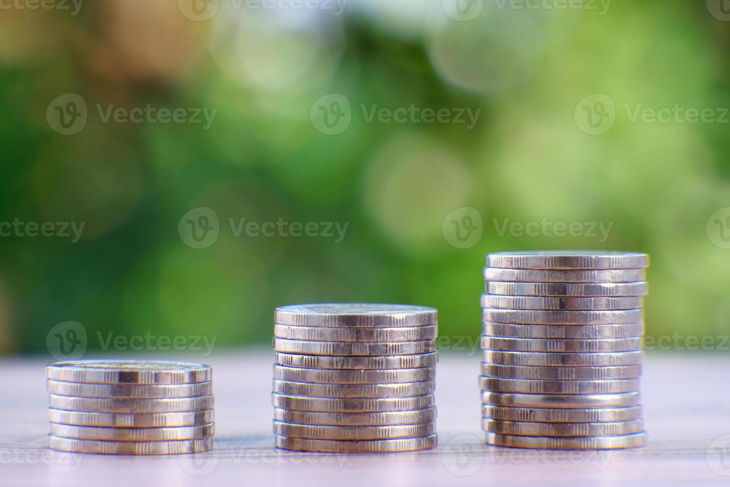 pile de pièces de monnaie sur un fond de nature verdoyante photo