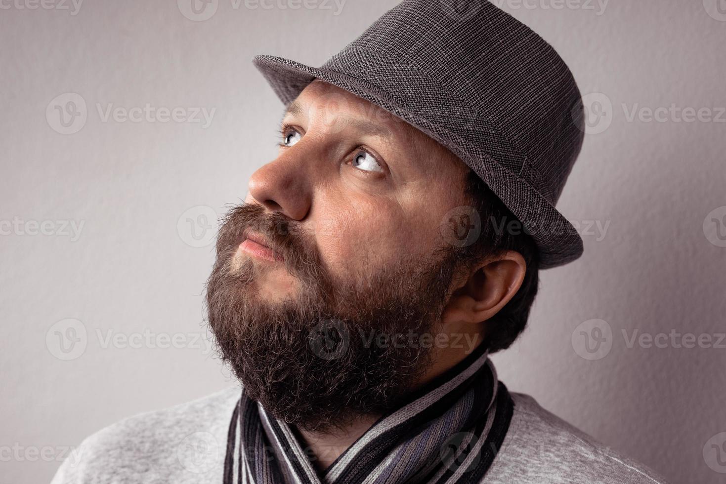 Jeune homme barbu hipster portant un chapeau et une écharpe gris photo