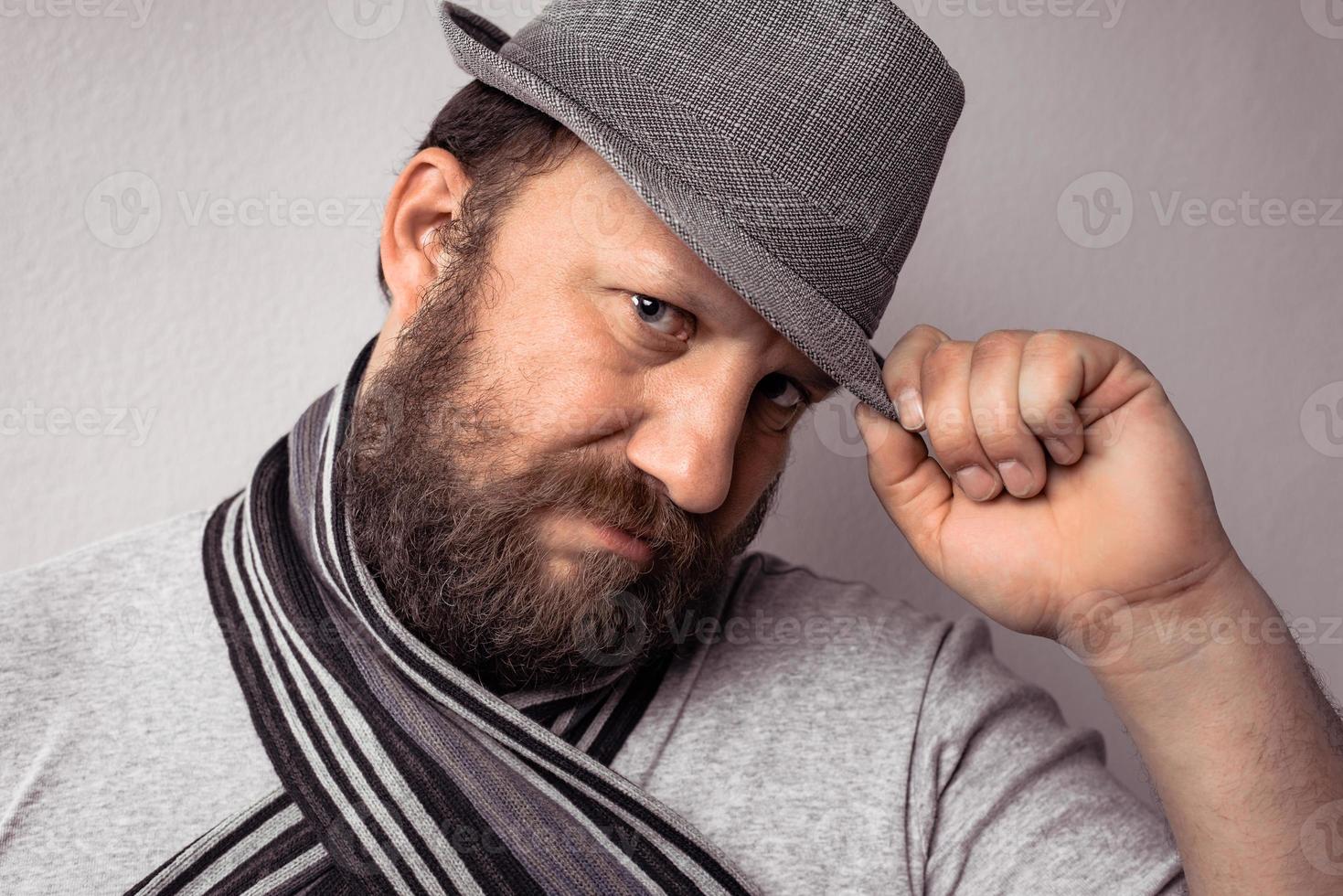 Jeune homme barbu hipster portant un chapeau et une écharpe gris photo