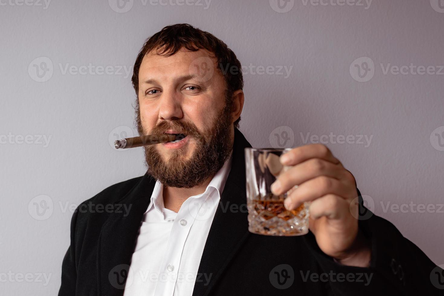 homme barbu en manteau et chemise modernes fumant son cigare photo
