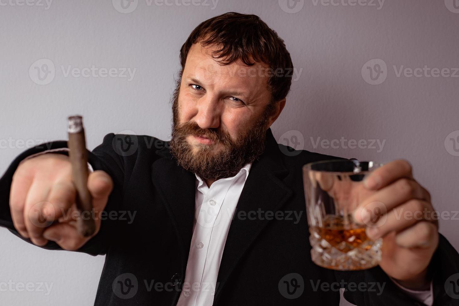 homme barbu en manteau et chemise modernes fumant son cigare photo