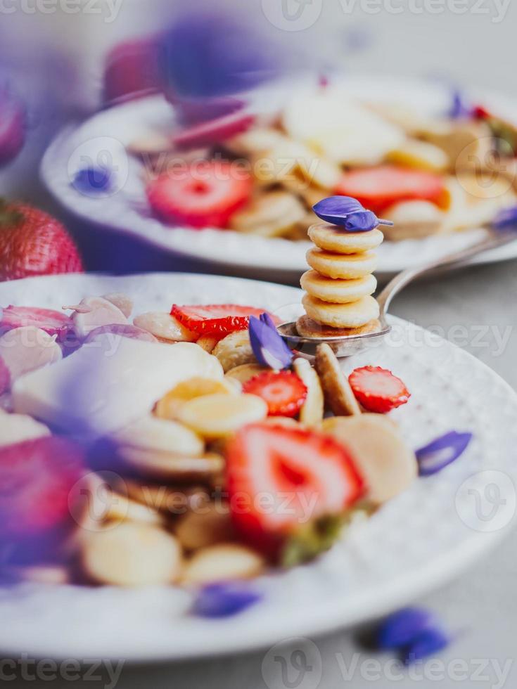 crêpes aux céréales, nourriture à la mode. mini crêpes aux céréales avec du beurre, du miel et des fraises. photo