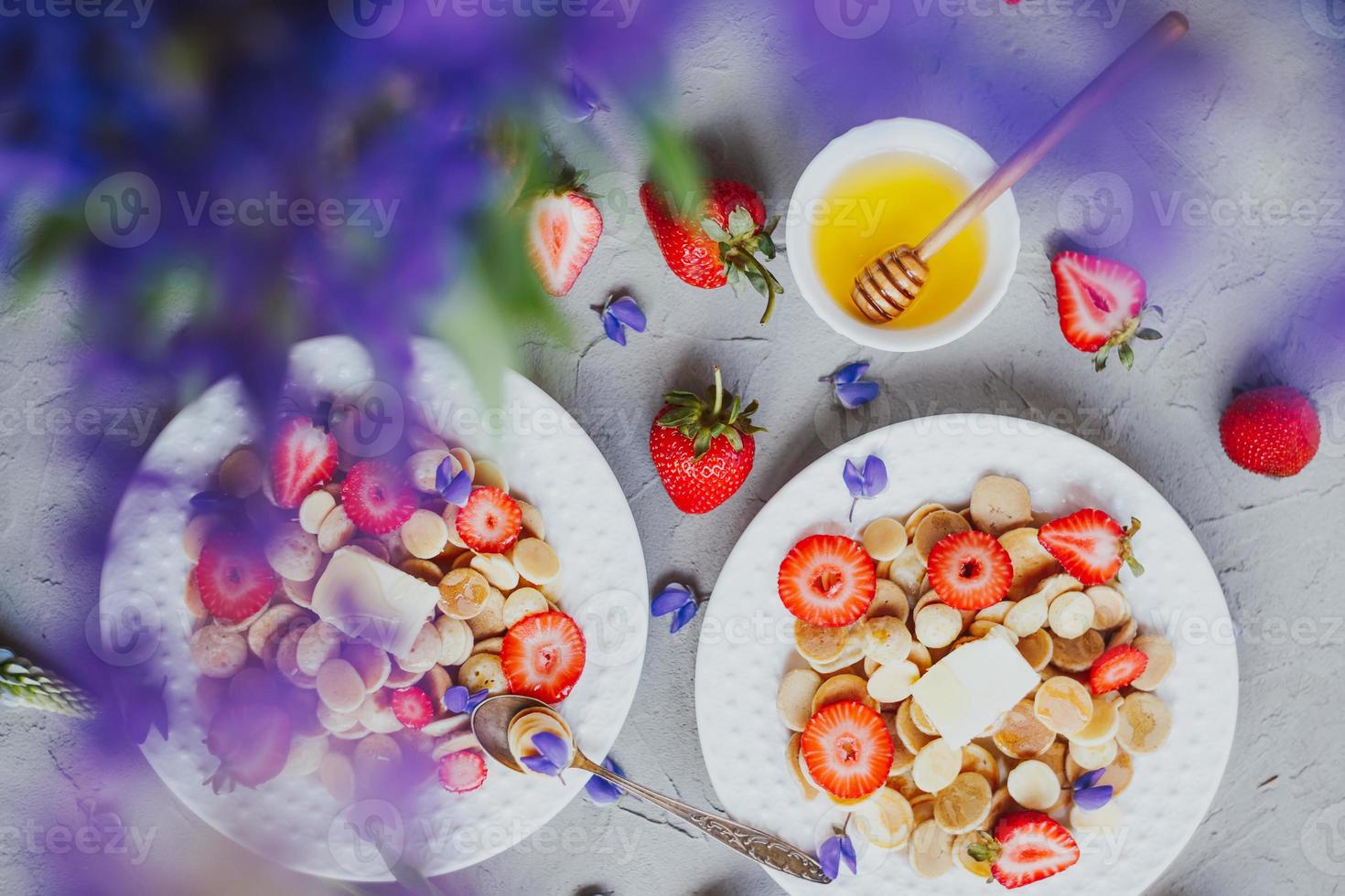 crêpes aux céréales, nourriture à la mode. mini crêpes aux céréales avec du beurre, du miel et des fraises. photo