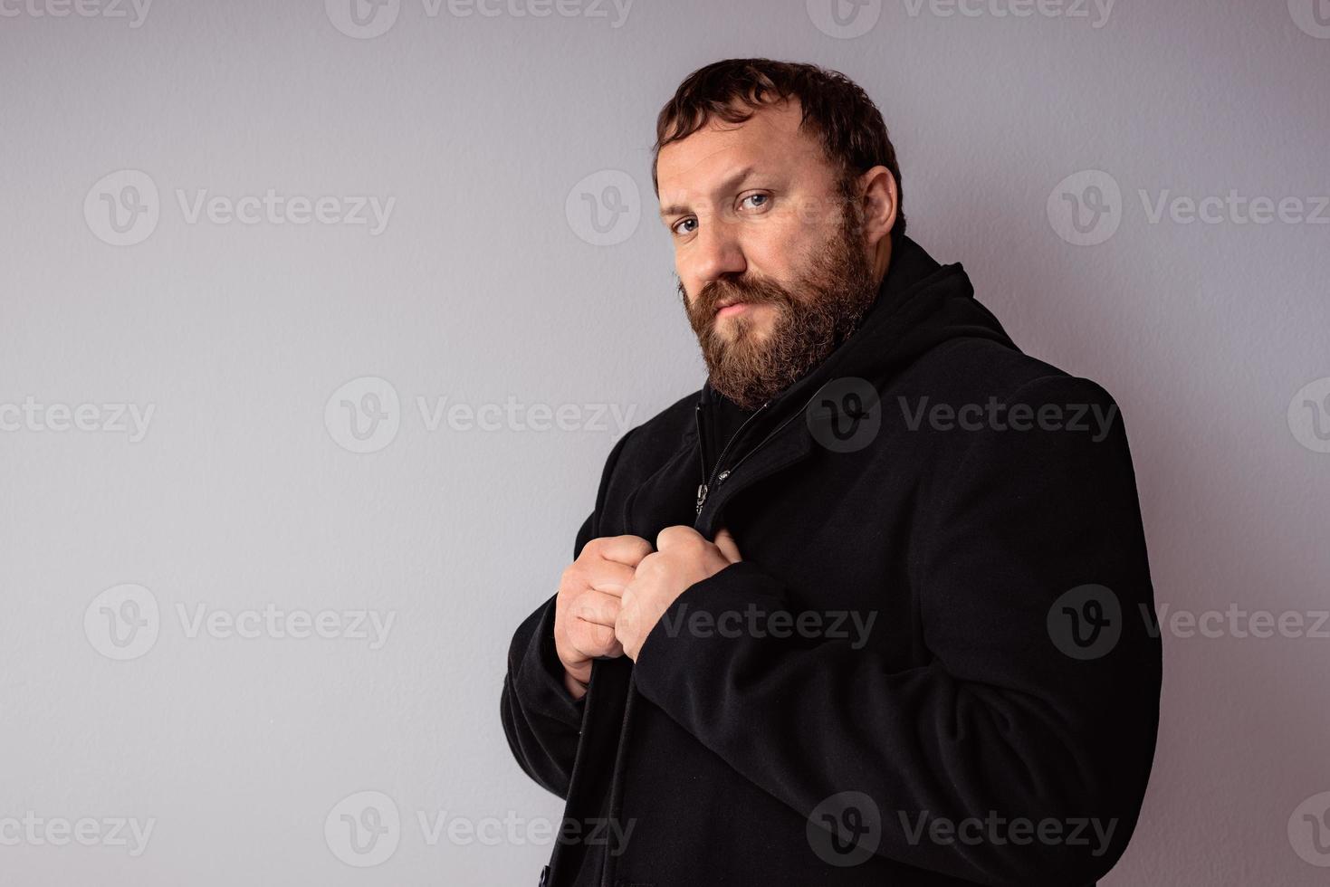 bel homme barbu élégant portant un manteau noir photo