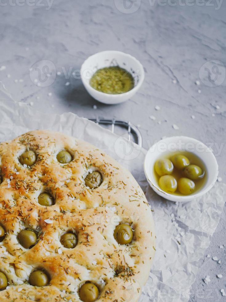 pain focaccia italien traditionnel aux olives, romarin, sel et huile d'olive. fougasse maison. photo
