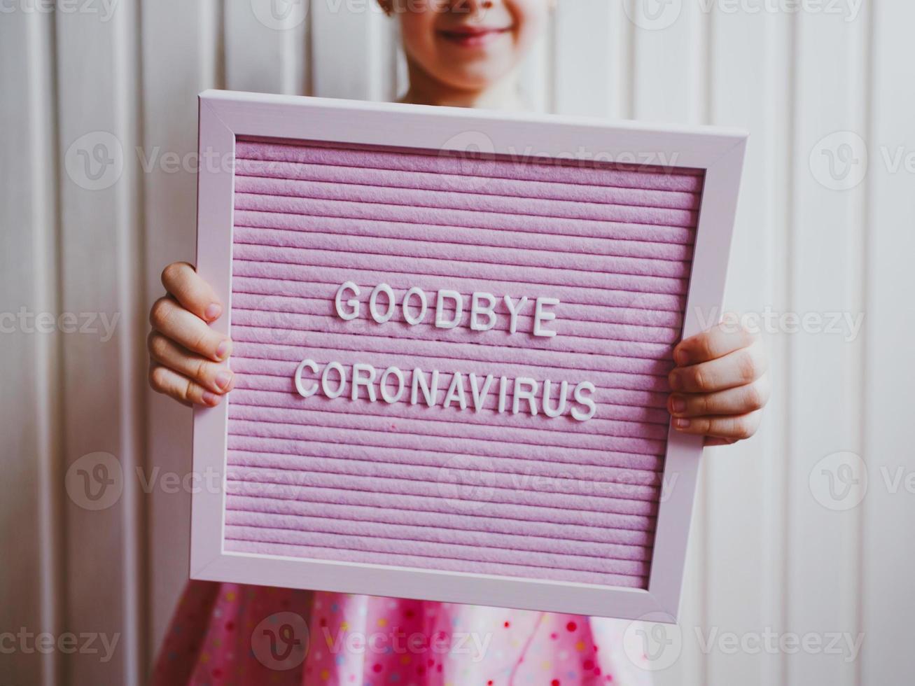 au revoir le coronavirus. fille tenant l'inscription au revoir coronavirus photo