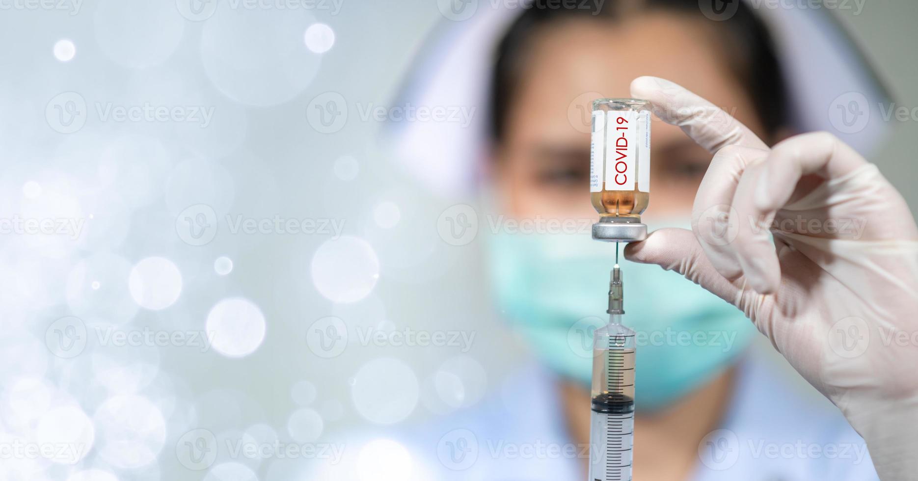 le médecin a mis un masque et s'injectait le coronavirus covid-19. photo