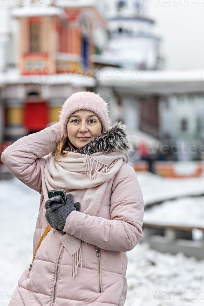 portrait d'une jeune femme en vêtements d'hiver chauds à l'extérieur lors d'un voyage. heure d'hiver, neige photo