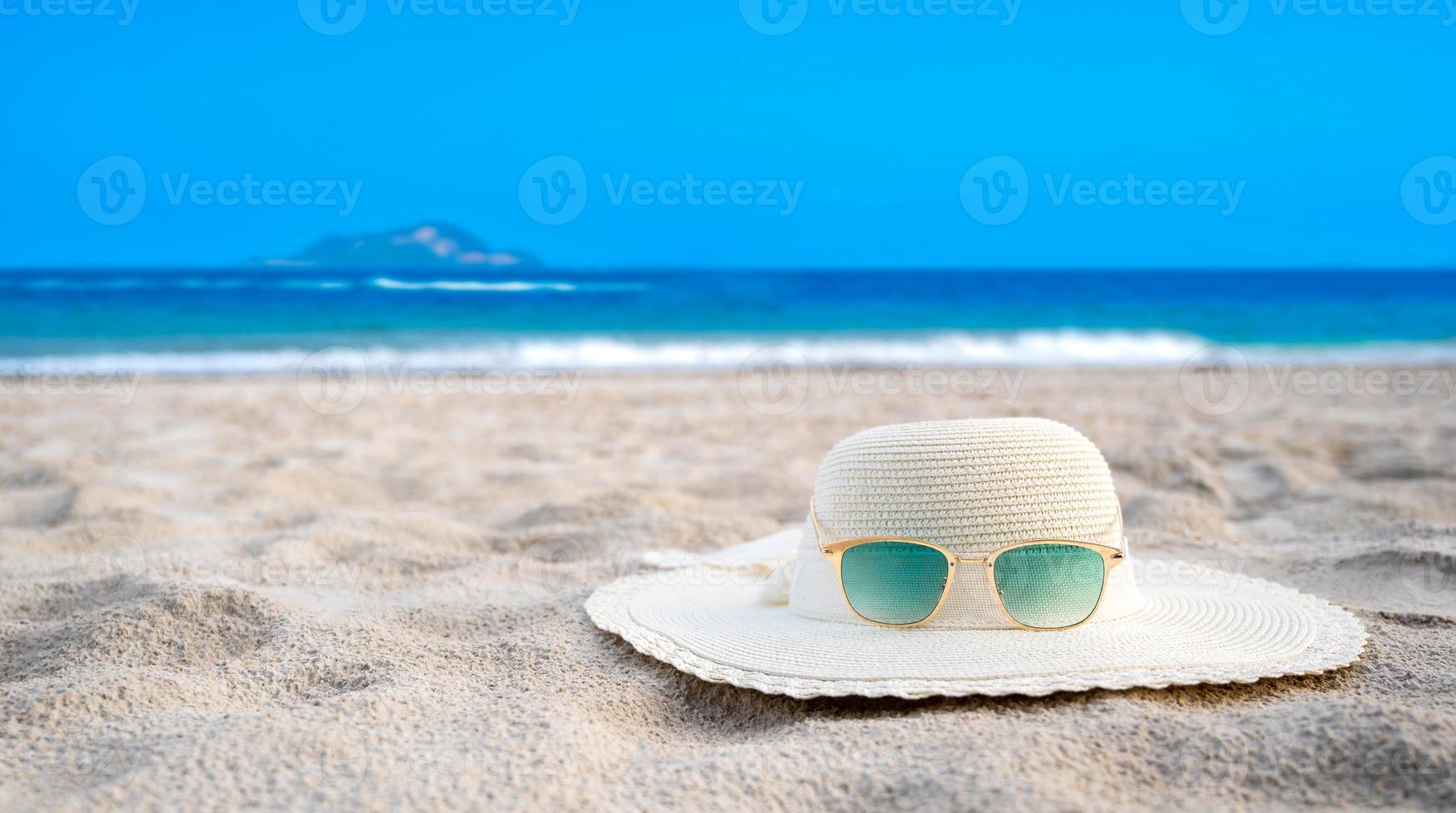 chapeaux et lunettes sont situés sur les plages de la mer bleue par temps clair photo