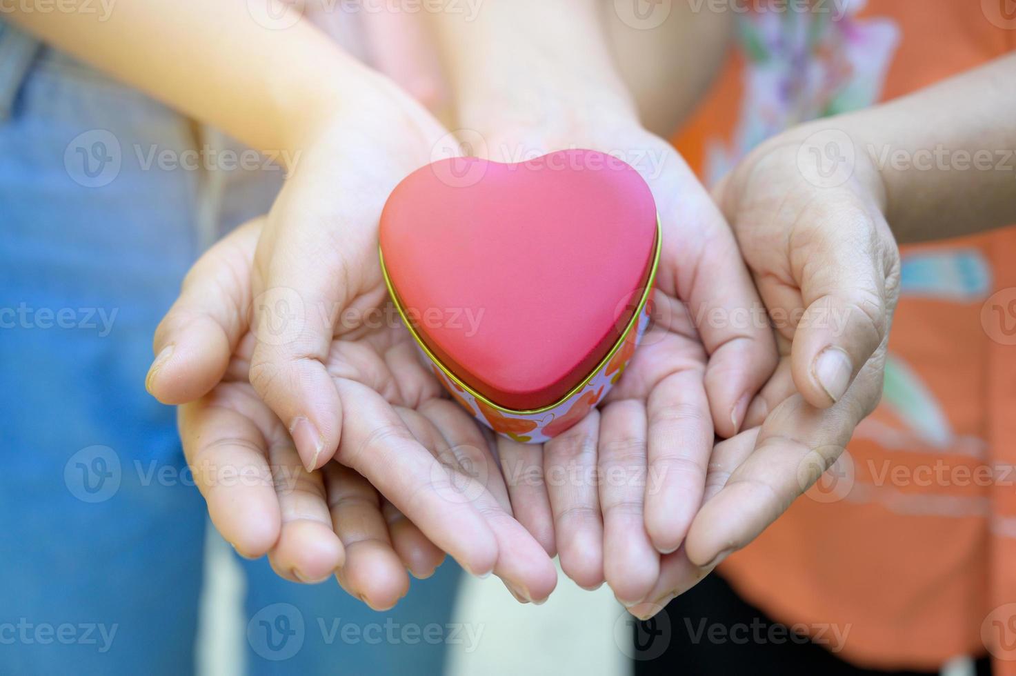 les mains des enfants et des adultes de la famille ont un cœur entre leurs mains. photo