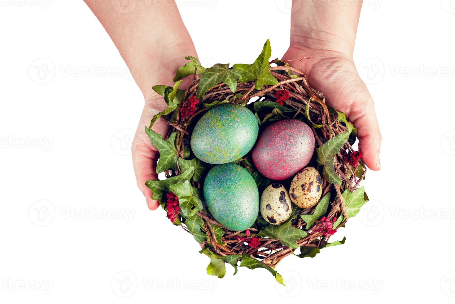 oeufs de pâques avec décoration. oeufs de caille dans un nid d'oiseau tenus par les mains de la femme. photo