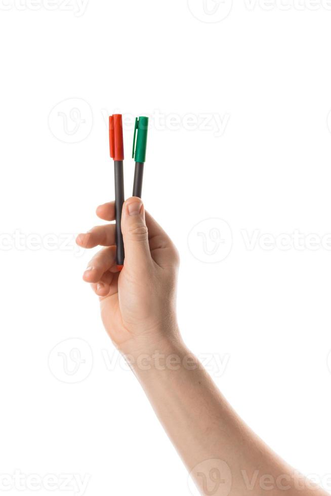la main masculine tient deux marqueurs rouges et verts ou un feutre. isolé sur fond blanc. photo