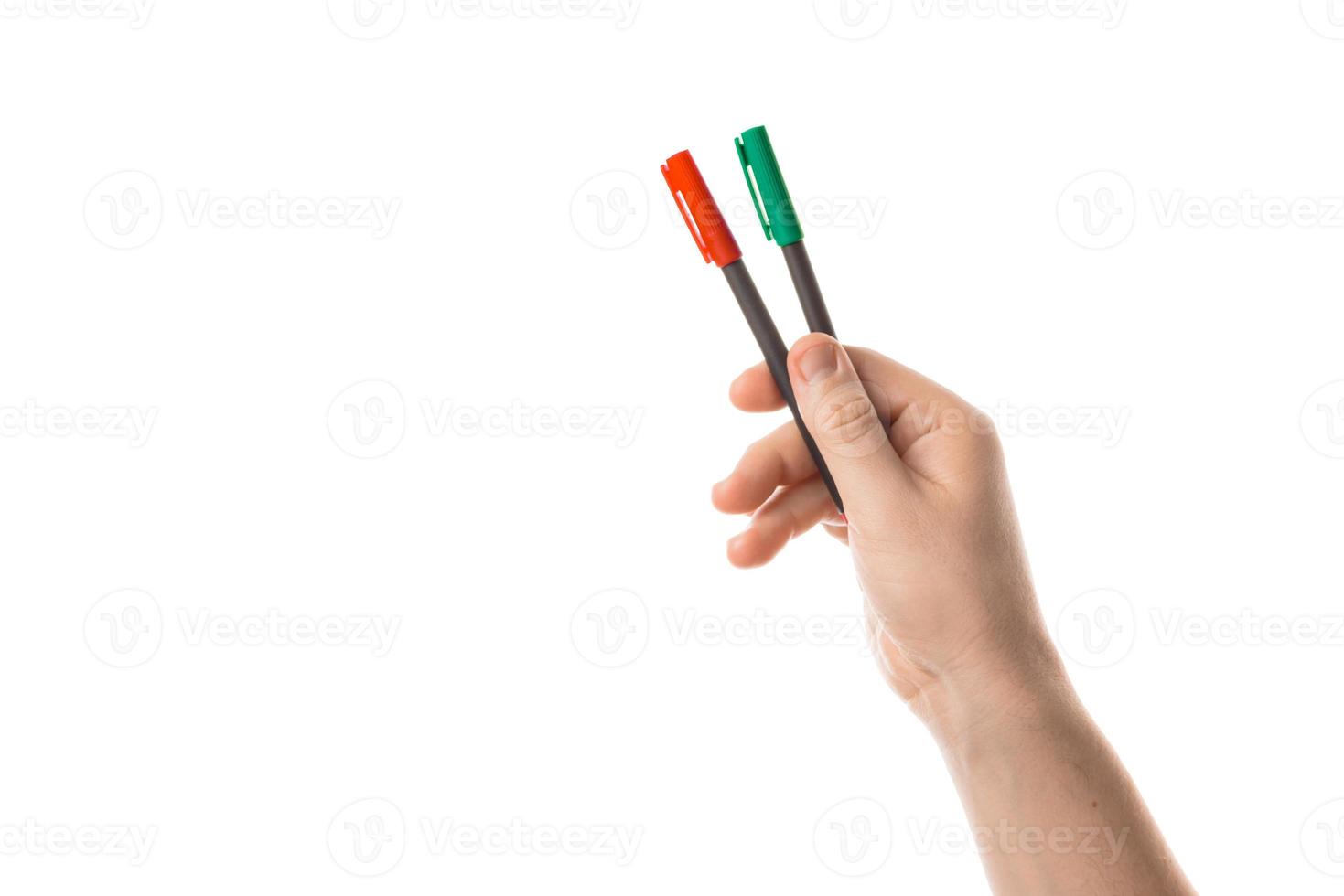 la main masculine tient deux marqueurs rouges et verts ou un feutre. isolé sur fond blanc. photo
