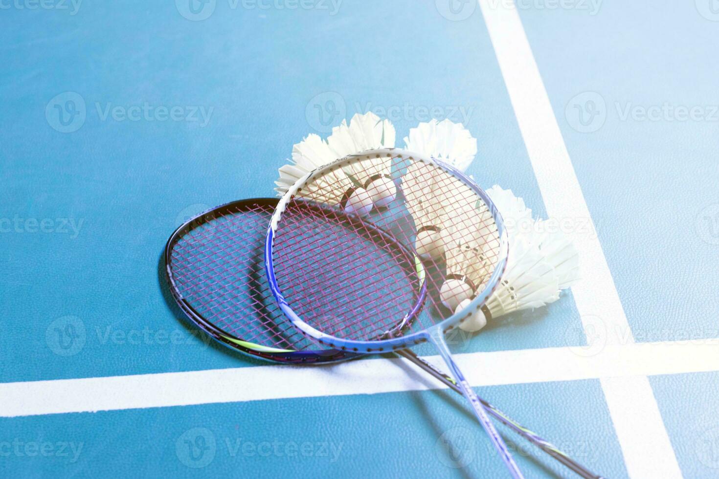 volant de badminton blanc crème et raquette au sol dans un terrain de badminton intérieur, espace de copie, mise au point douce et sélective sur les volants. photo