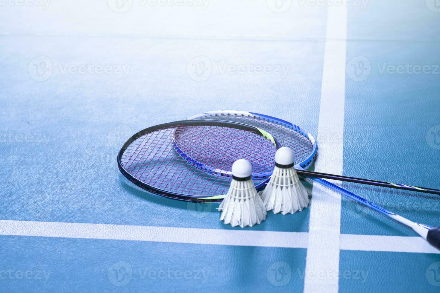 volant de badminton blanc crème et raquette au sol dans un terrain de badminton intérieur, espace de copie, mise au point douce et sélective sur les volants. photo