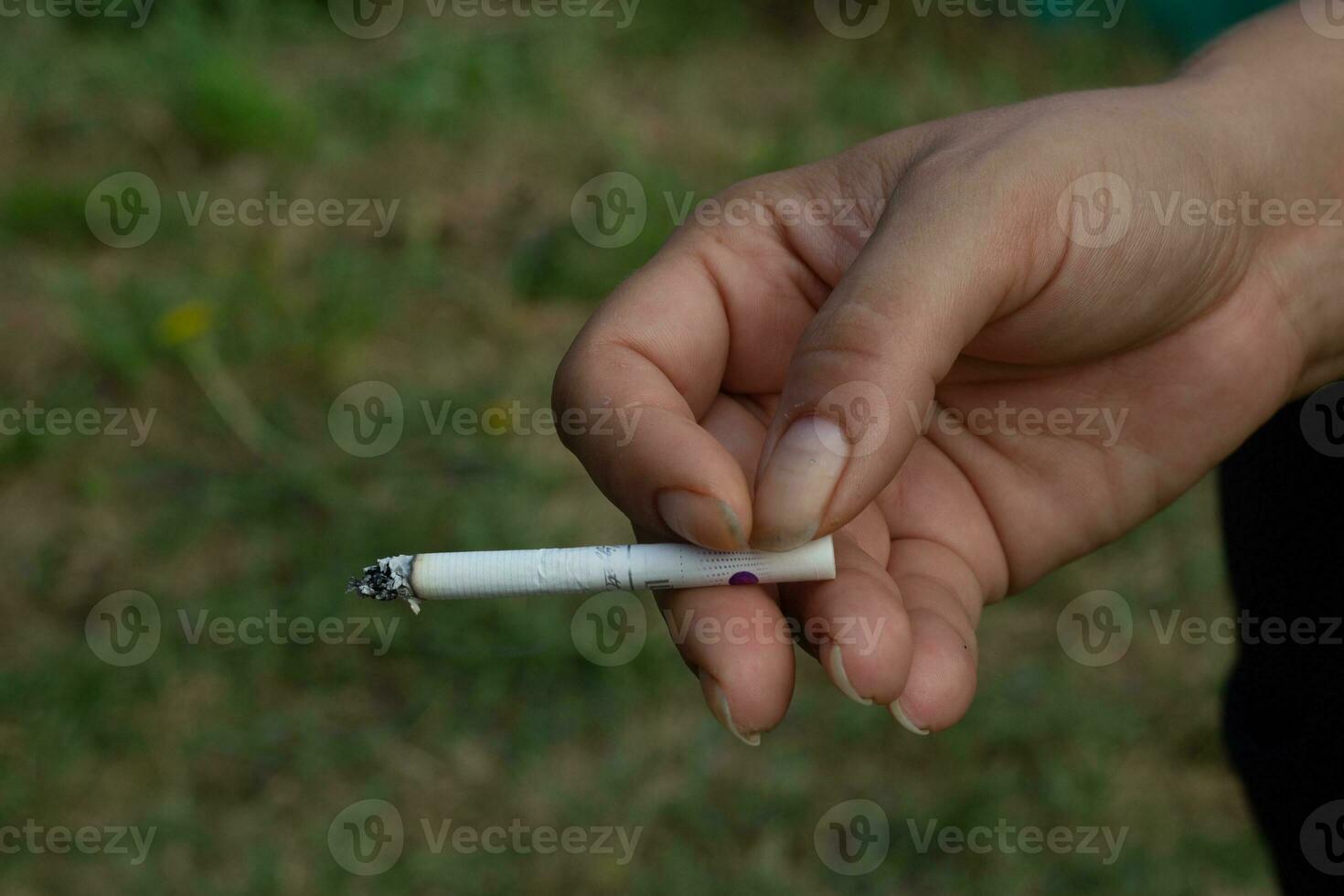 une femme main est en portant une cigarette rue photo