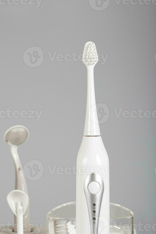 ultrasonique brosse à dents trousse sur une gris Contexte. photo