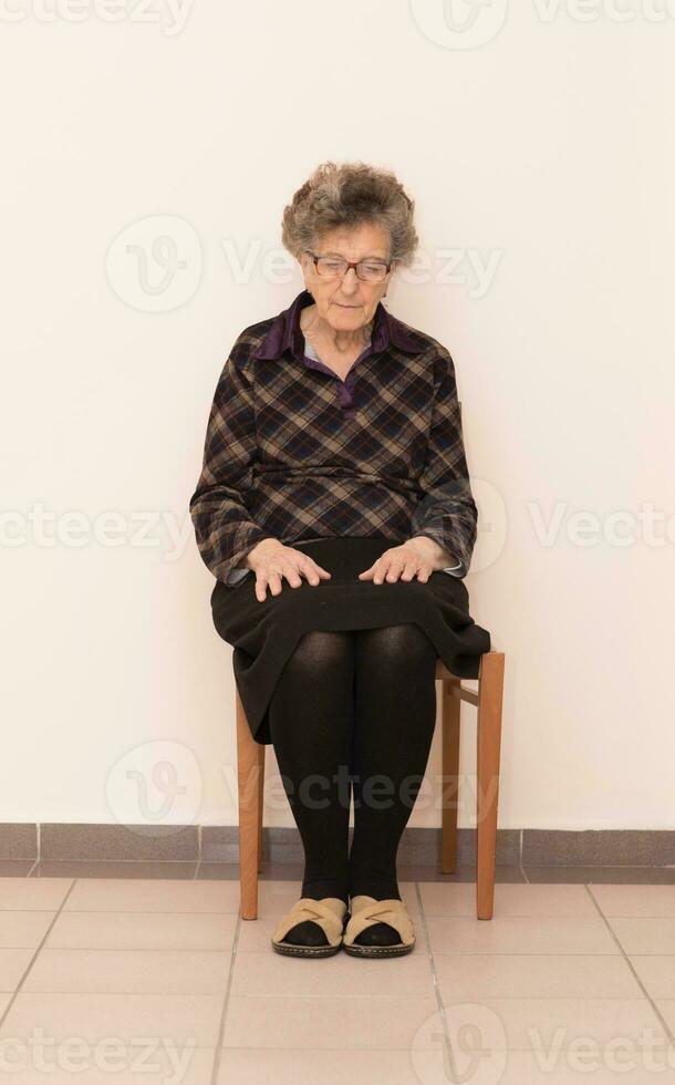 vieux femme est séance une le chaise photo