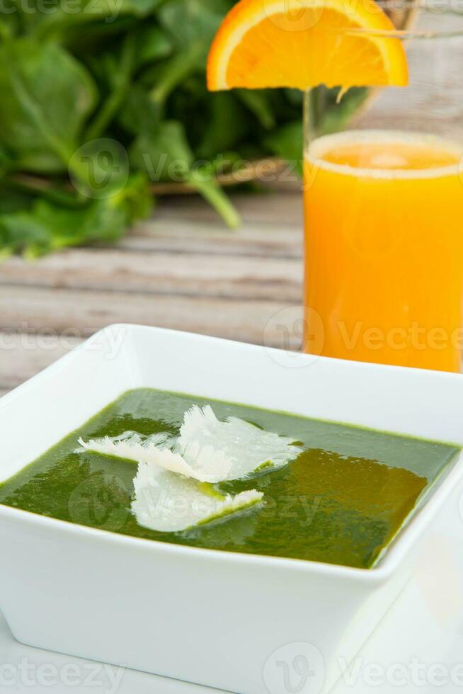 épinard crème soupe et une verre de Frais Orange jus photo