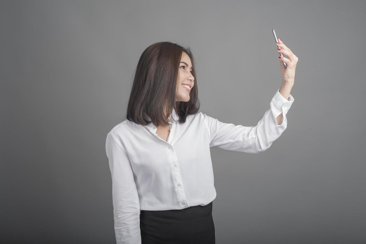 femme d'affaires en chemise blanche sur fond gris photo