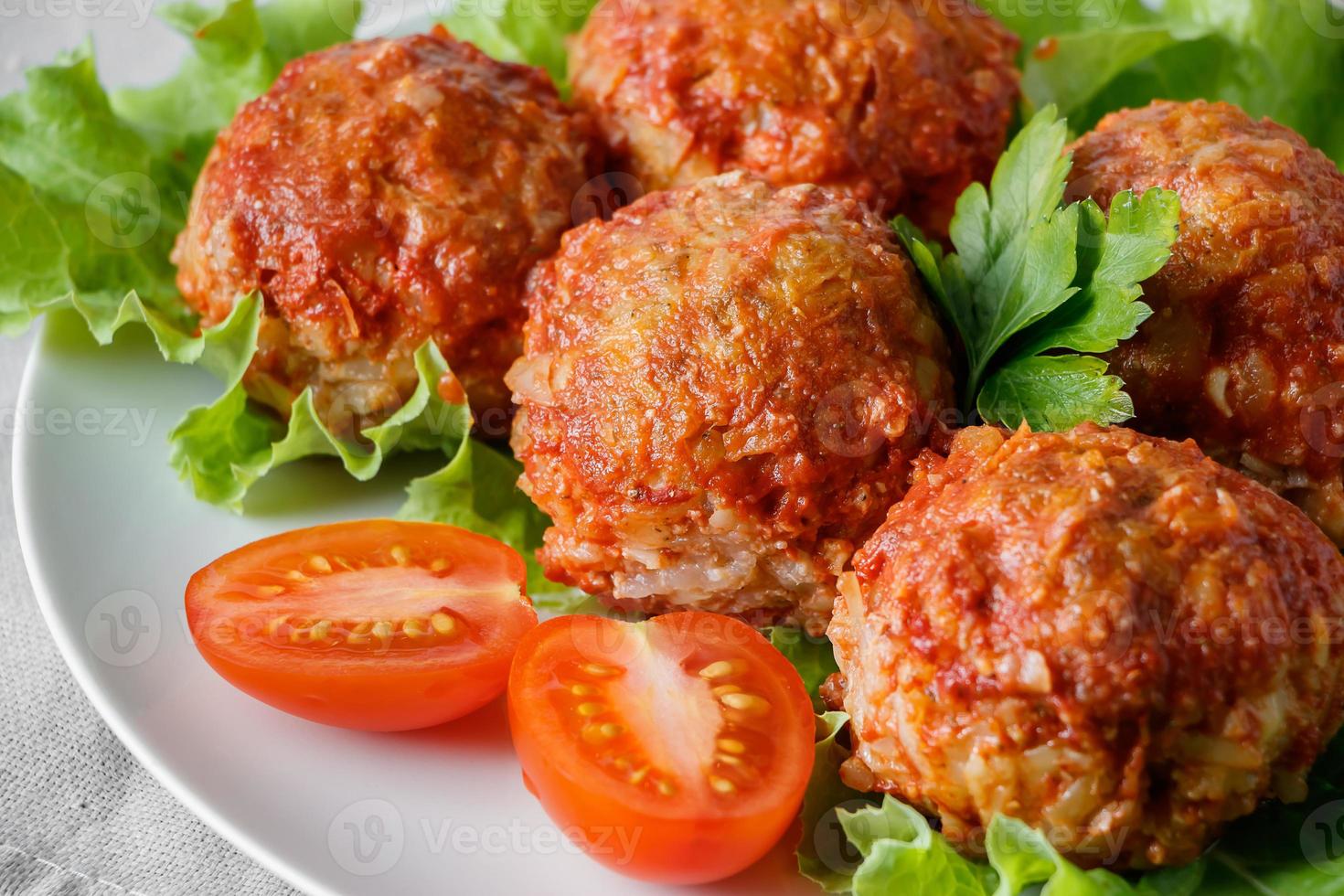 boulettes de viande maison avec légumes à la sauce tomate. plat de protéines appétissant sur une assiette. photo