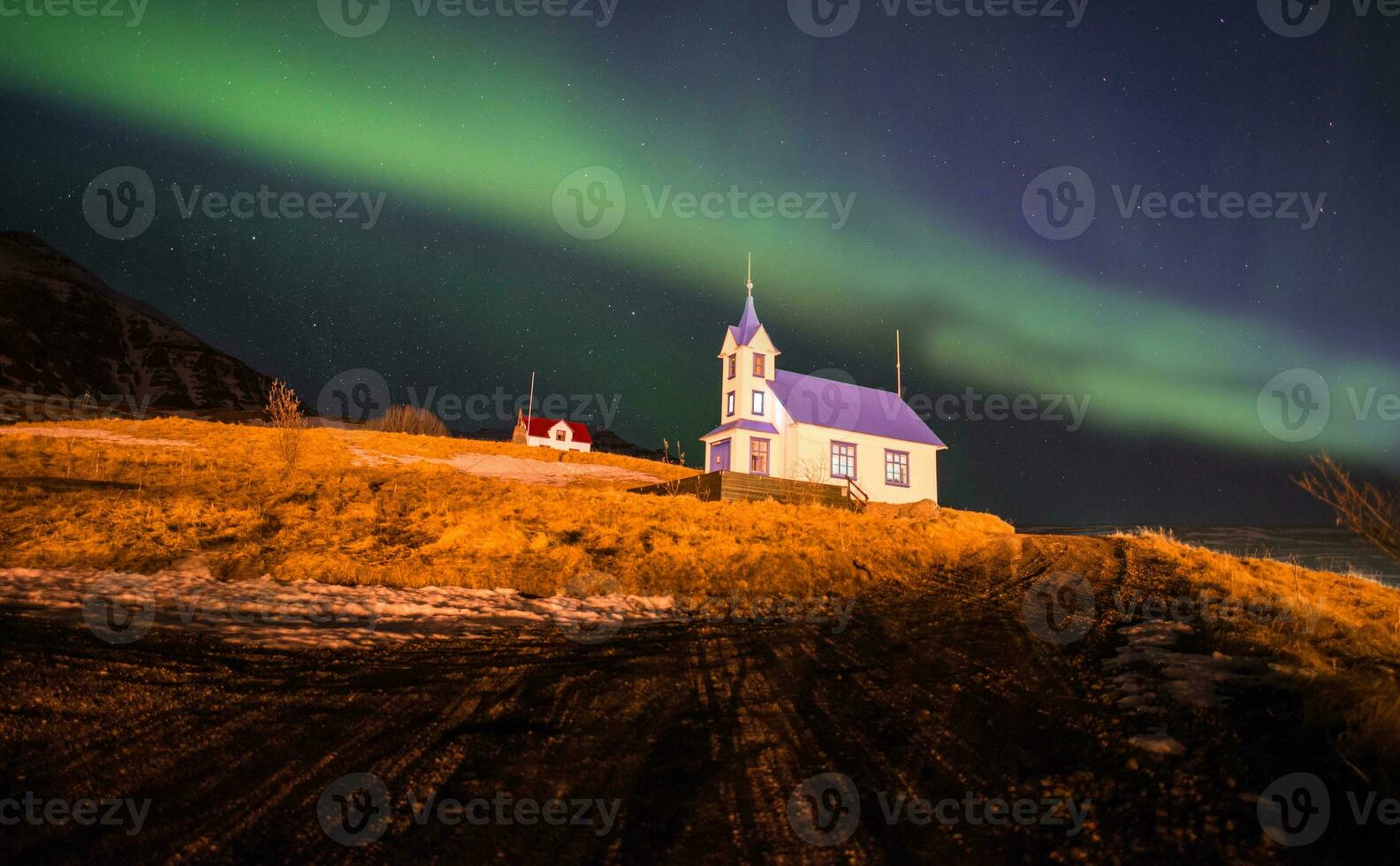 le magnifique aurore borealis plus de le église dans stodvarfjordur ville dans est Islande. photo