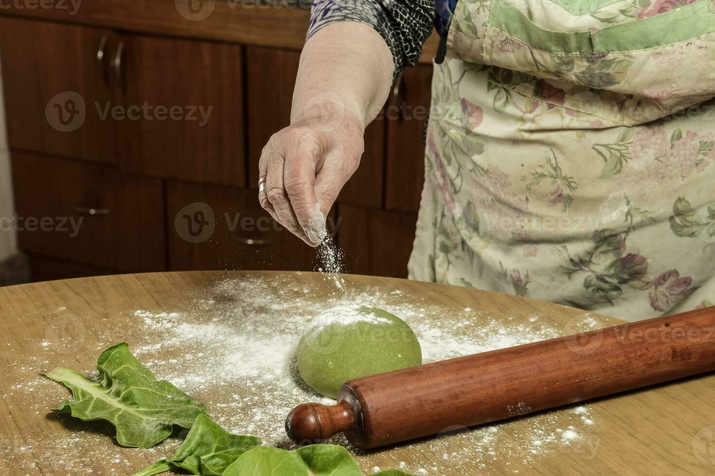de grand-mère mains pétrissage, pâte pour vert nouilles. photo
