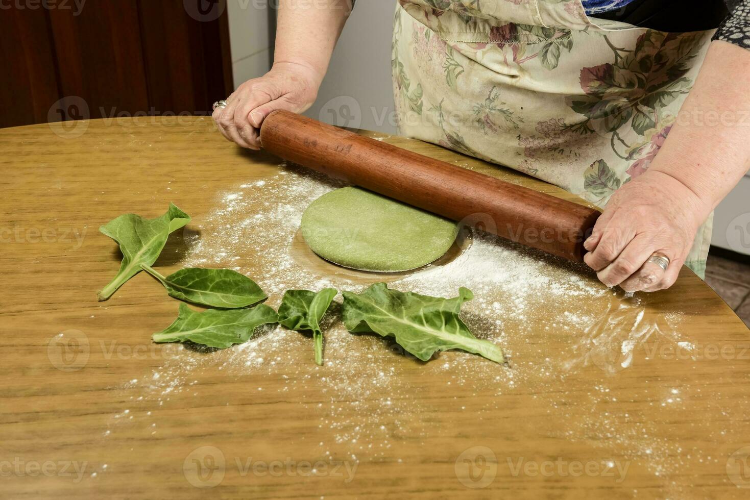 de grand-mère mains pétrissage, pâte pour vert nouilles. photo