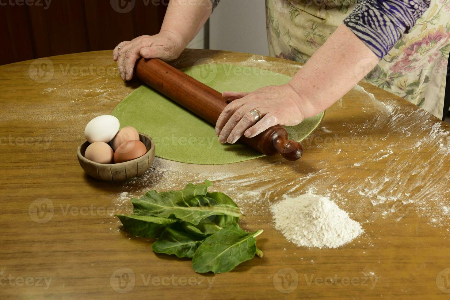 de grand-mère mains pétrissage, pâte pour vert nouilles. photo