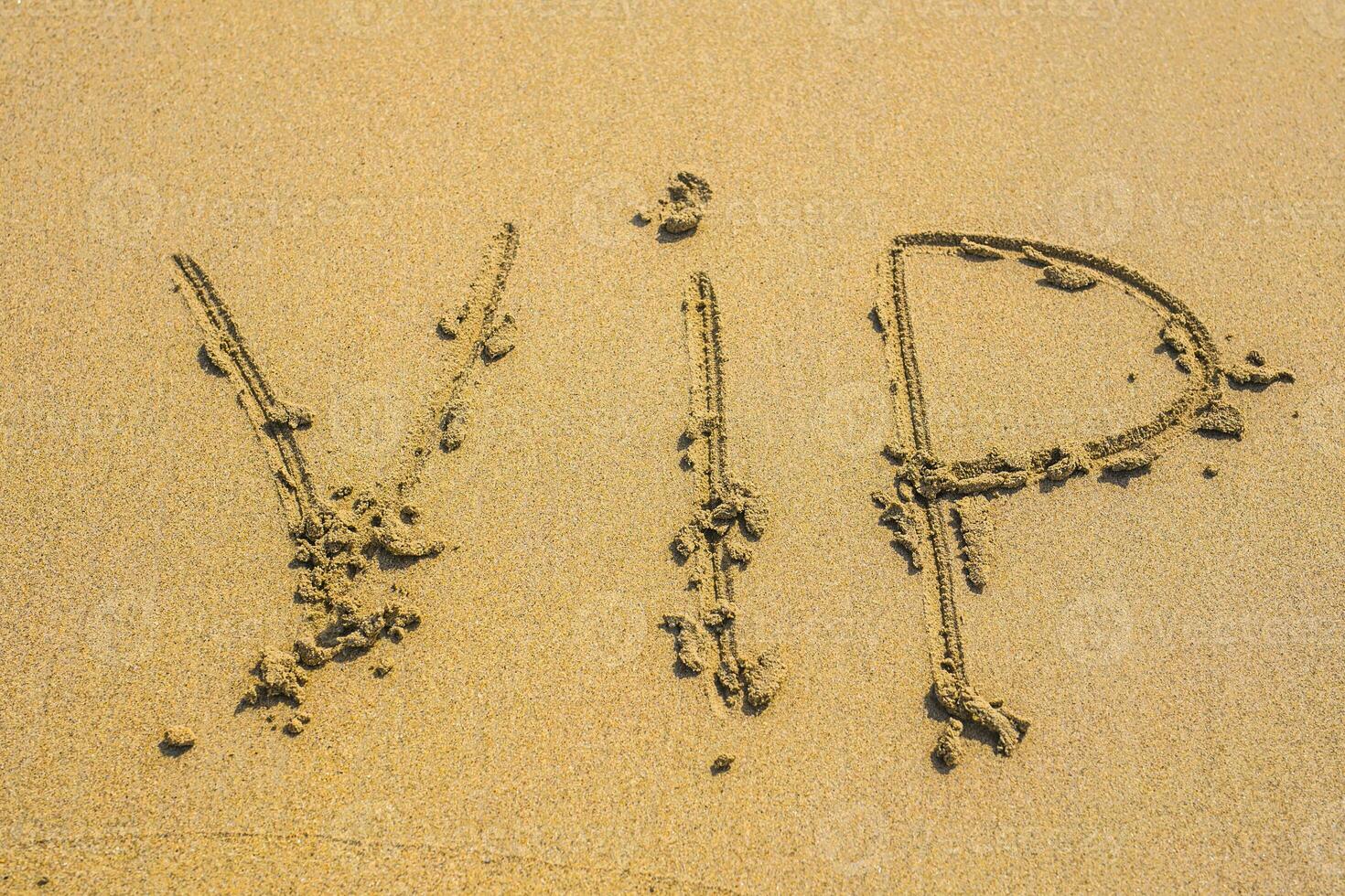 écrit mot VIP sur le sable de plage dans ensoleillé journée photo