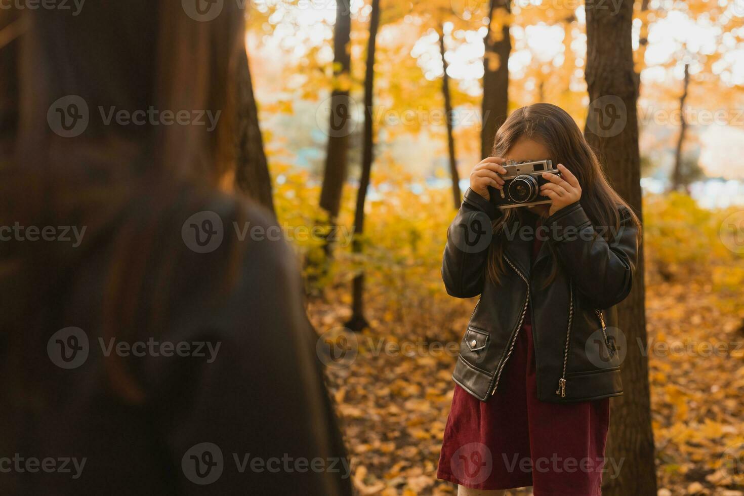 enfant prise image sa mère sur rétro caméra dans l'automne parc. loisirs et loisir concept. photo