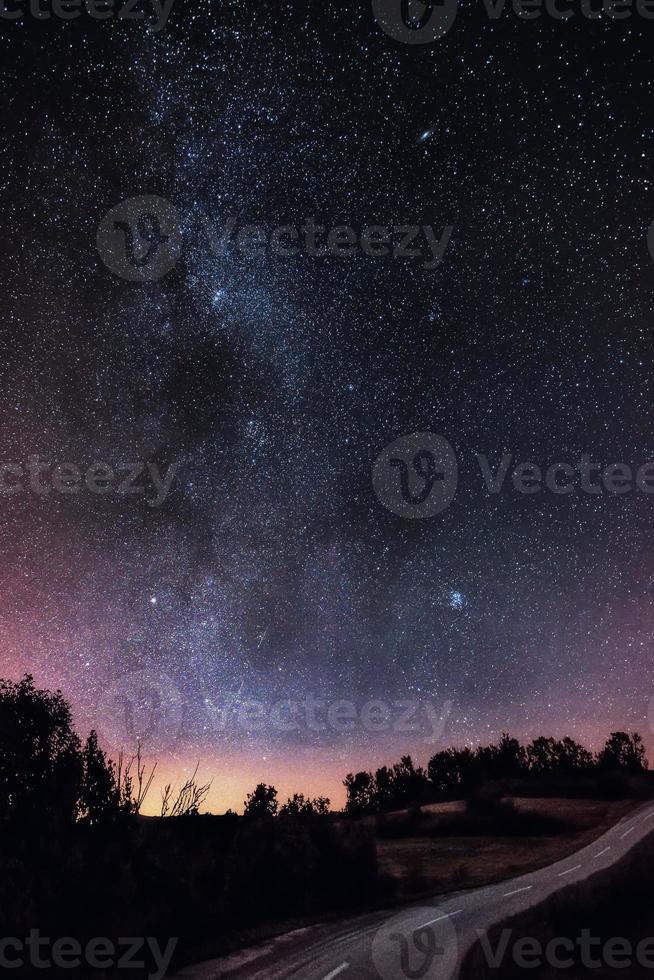 galaxie de la voie lactée sur la route forestière. galaxie de la voie lactée sur la route forestière de montagne, rajac, serbie. le ciel nocturne est astronomiquement précis. photo