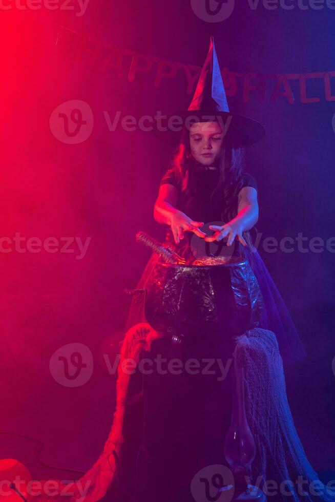 peu sorcière enfant cuisine potion dans le chaudron sur Halloween. photo