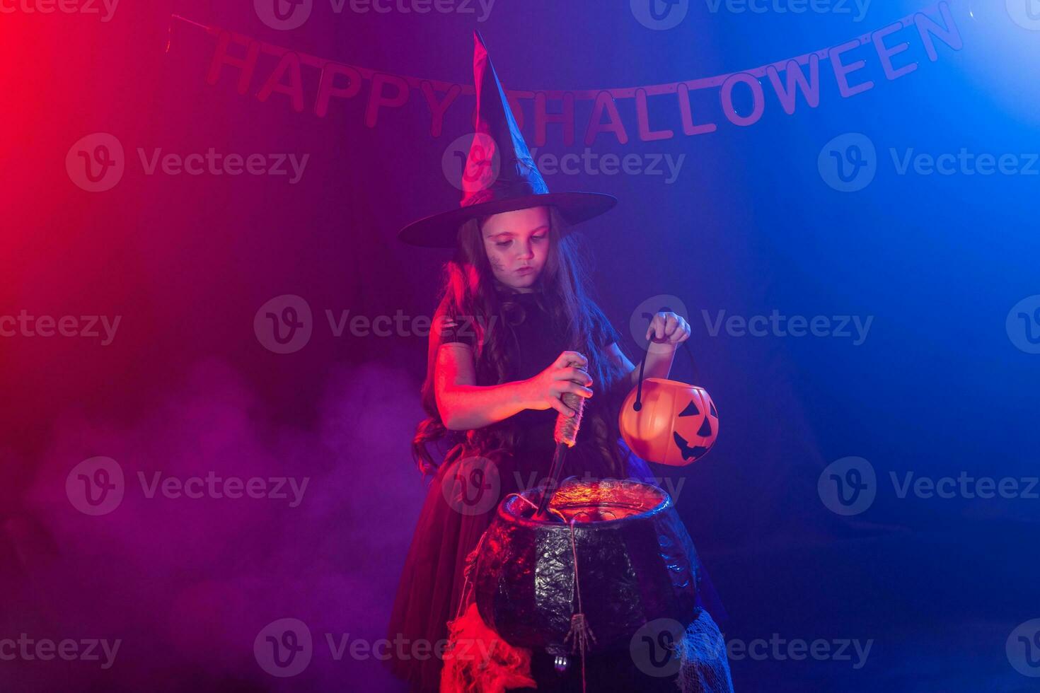 peu sorcière enfant cuisine potion dans le chaudron sur Halloween. photo