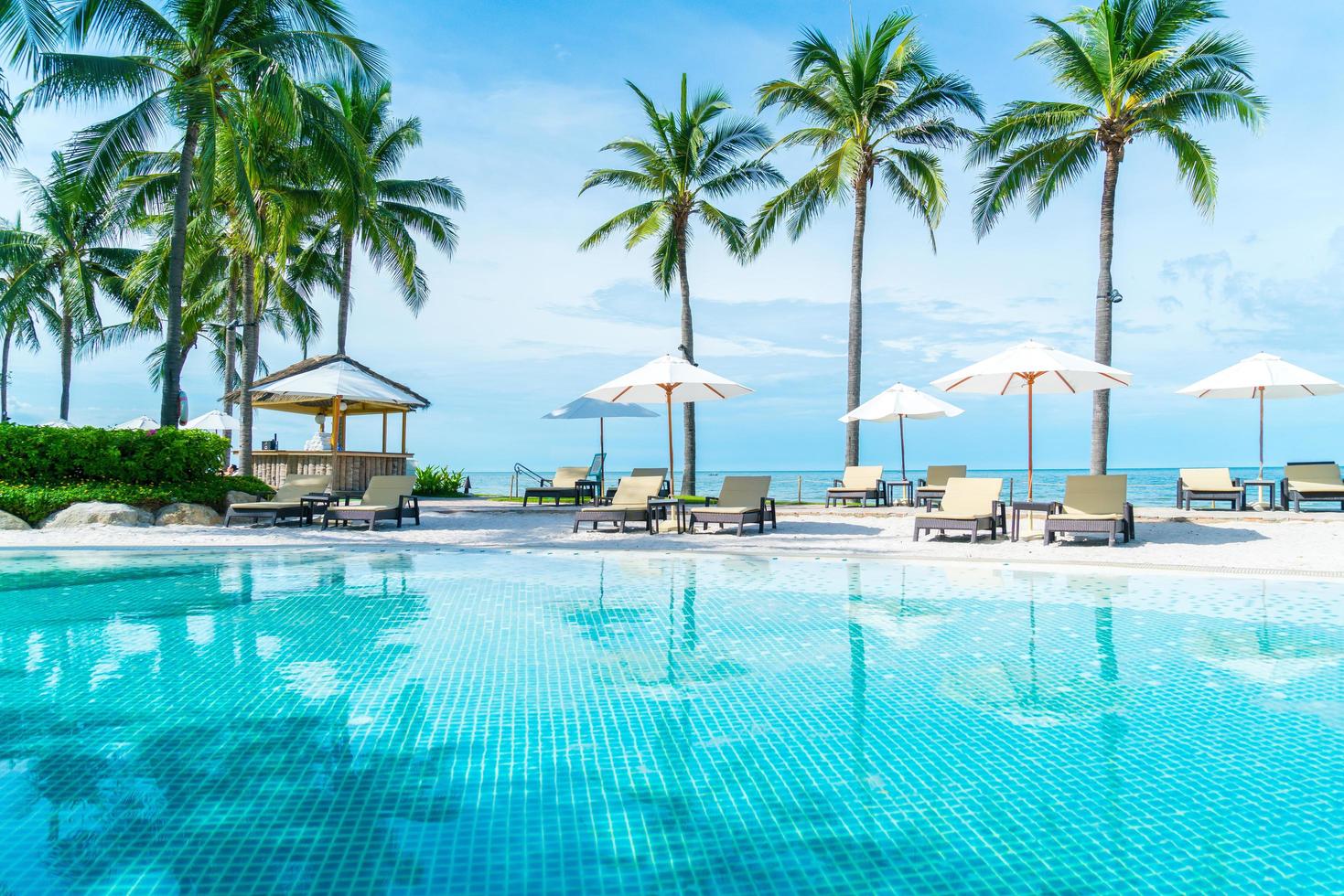 belle plage tropicale et mer avec parasol et chaise autour de la piscine de l'hôtel resort photo