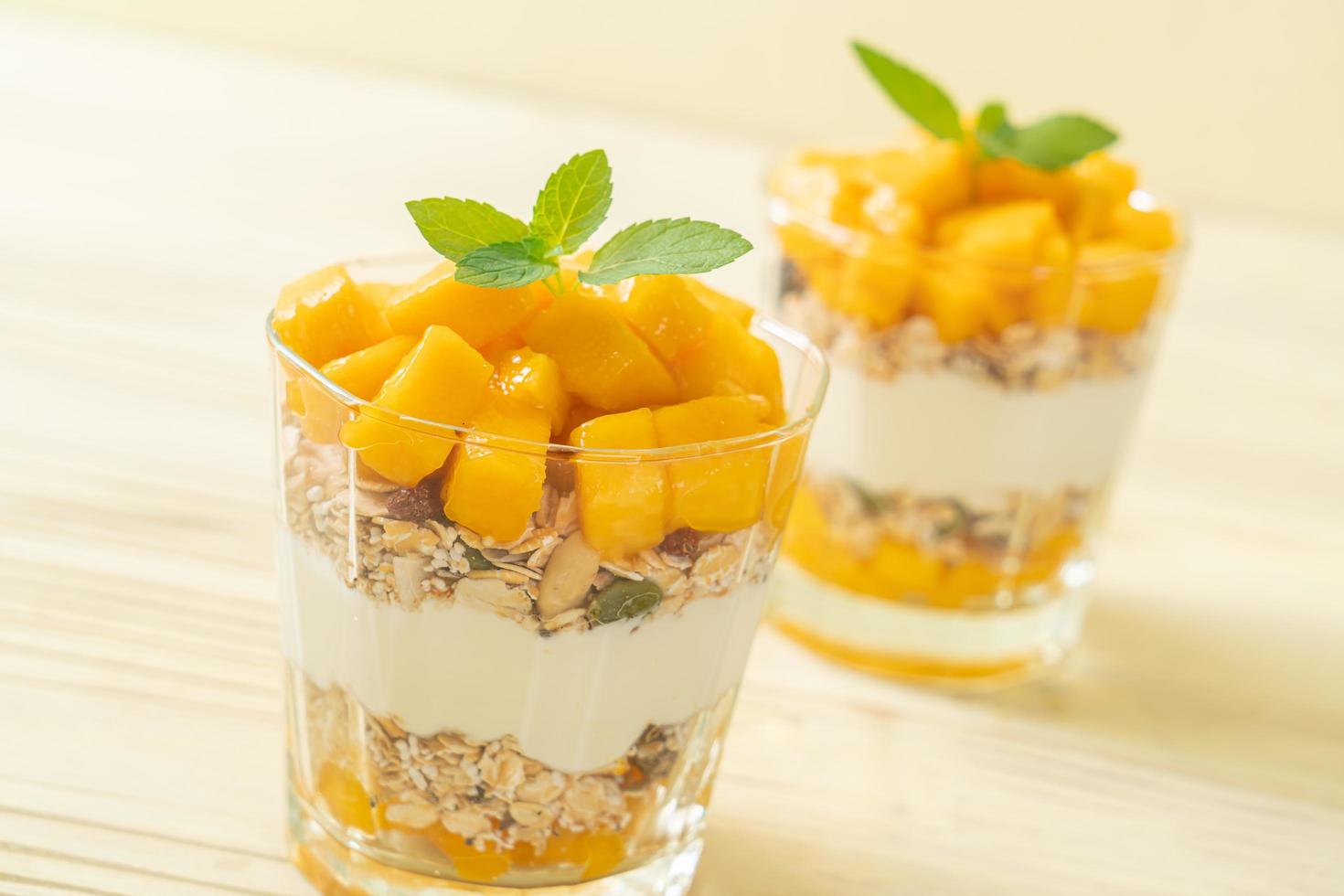 yaourt à la mangue fraîche avec granola en verre - style alimentaire sain photo