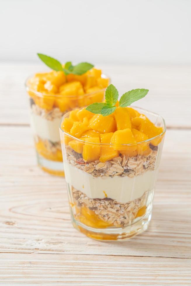 yaourt à la mangue fraîche avec granola en verre - style alimentaire sain photo