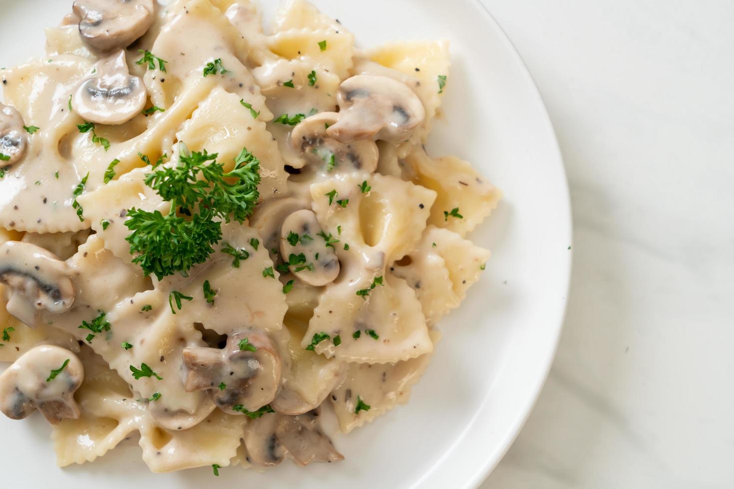 pâtes farfalle avec sauce crème blanche aux champignons - style cuisine italienne photo