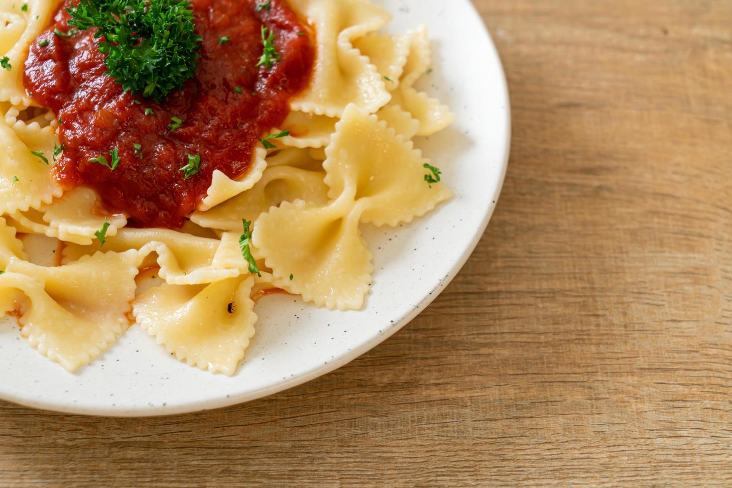 pâtes farfalle à la sauce tomate avec persil - style cuisine italienne photo