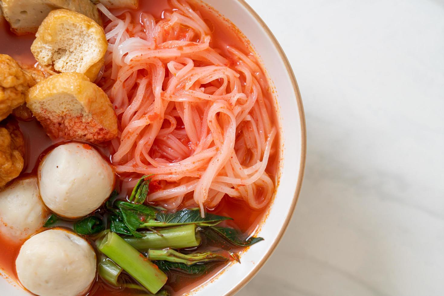 petites nouilles de riz plates avec boulettes de poisson et boulettes de crevettes dans une soupe rose, yen ta four ou yen ta fo - style cuisine asiatique photo