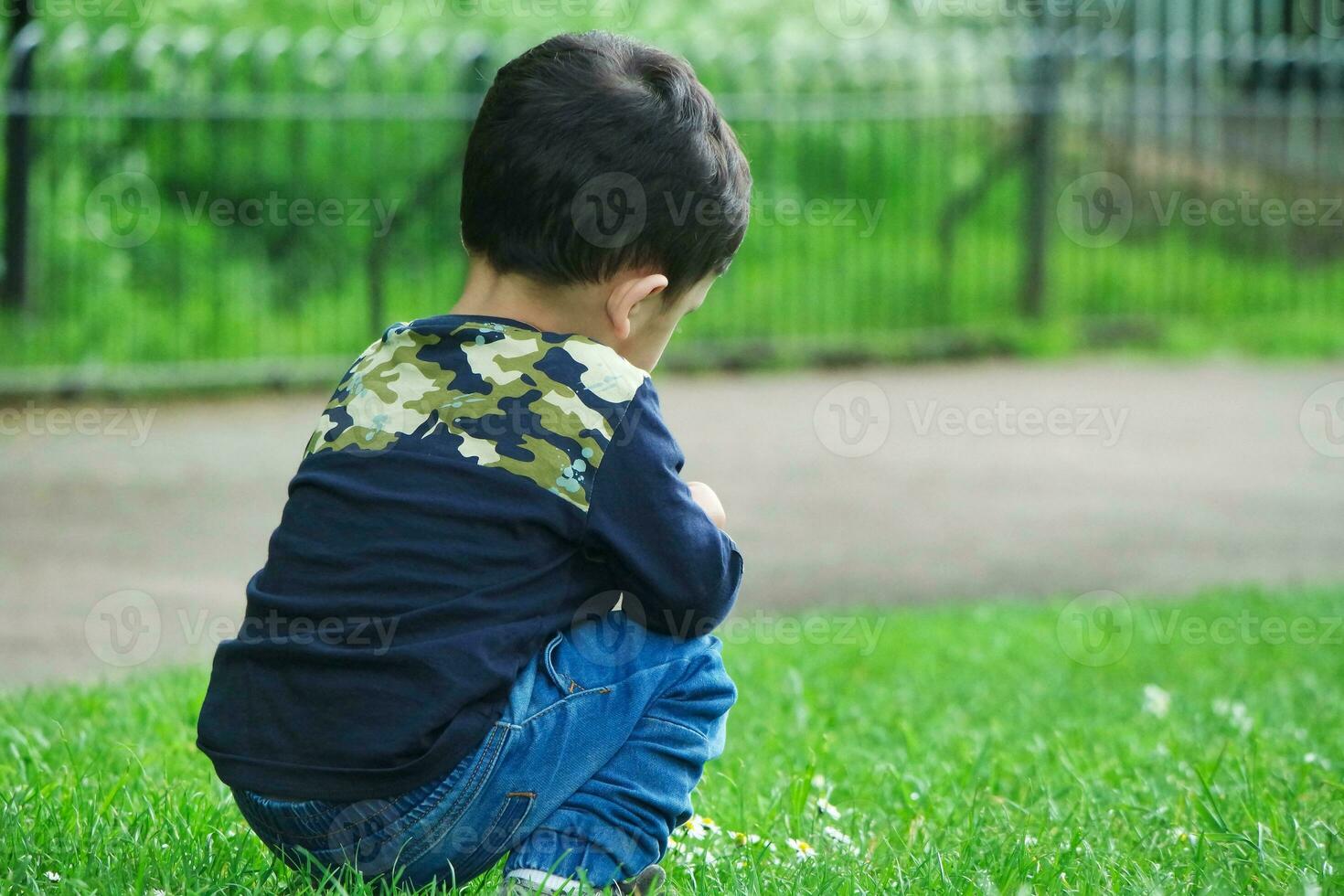 mignonne asiatique pakistanais bébé est profiter le magnifique ensoleillé journée à mise en garde les enfants et Publique parc de luton ville de Angleterre Royaume-Uni. faible angle image a été capturé sur avril 03ème, 2023 photo