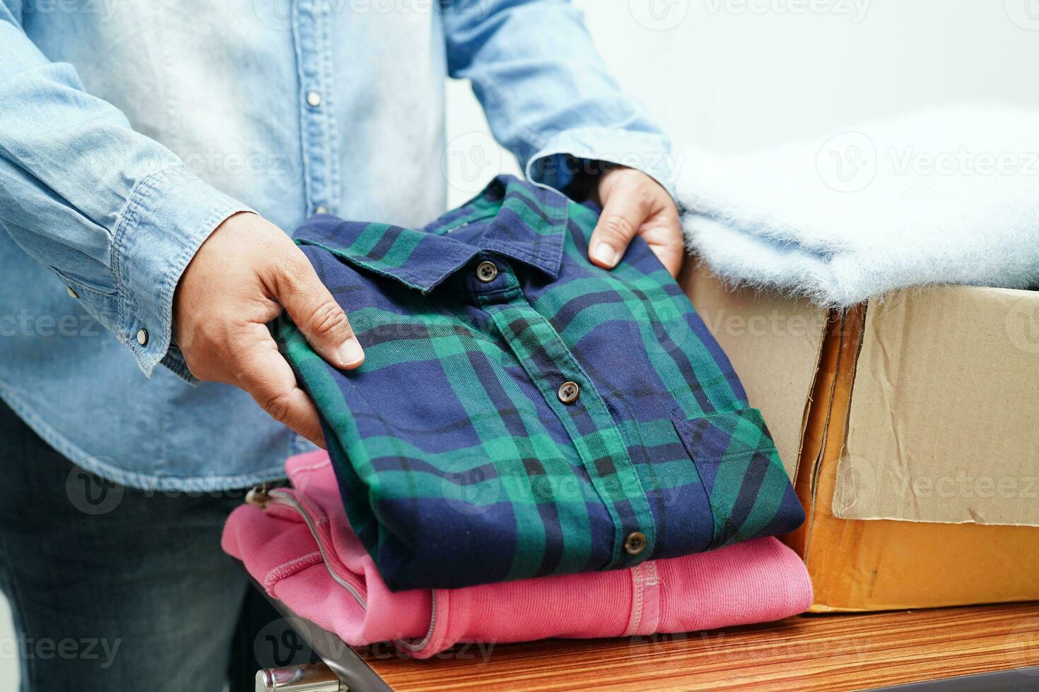 dons de vêtements dans une boîte en carton pour les bénévoles. photo