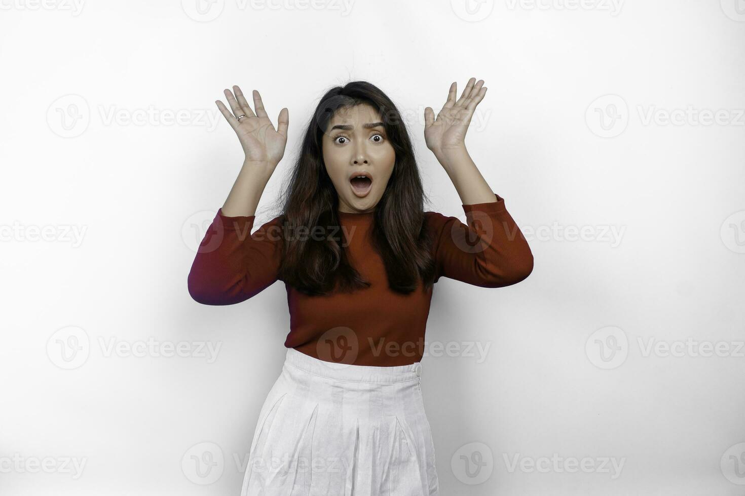 sous le choc asiatique femme portant rouge T-shirt, montrer du doigt à le copie espace au dessus son, isolé par blanc Contexte photo